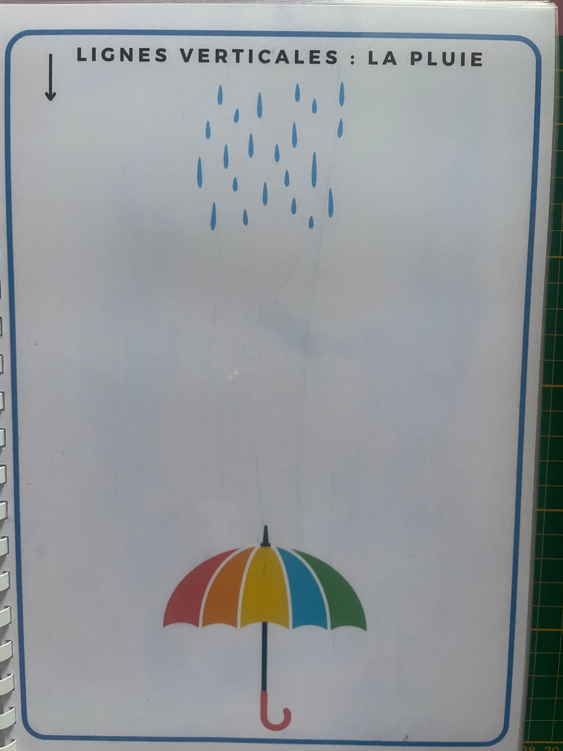Fiche du livret de graphisme avec lignes verticales représentant la pluie et un parapluie coloré pour motricité fine en maternelle