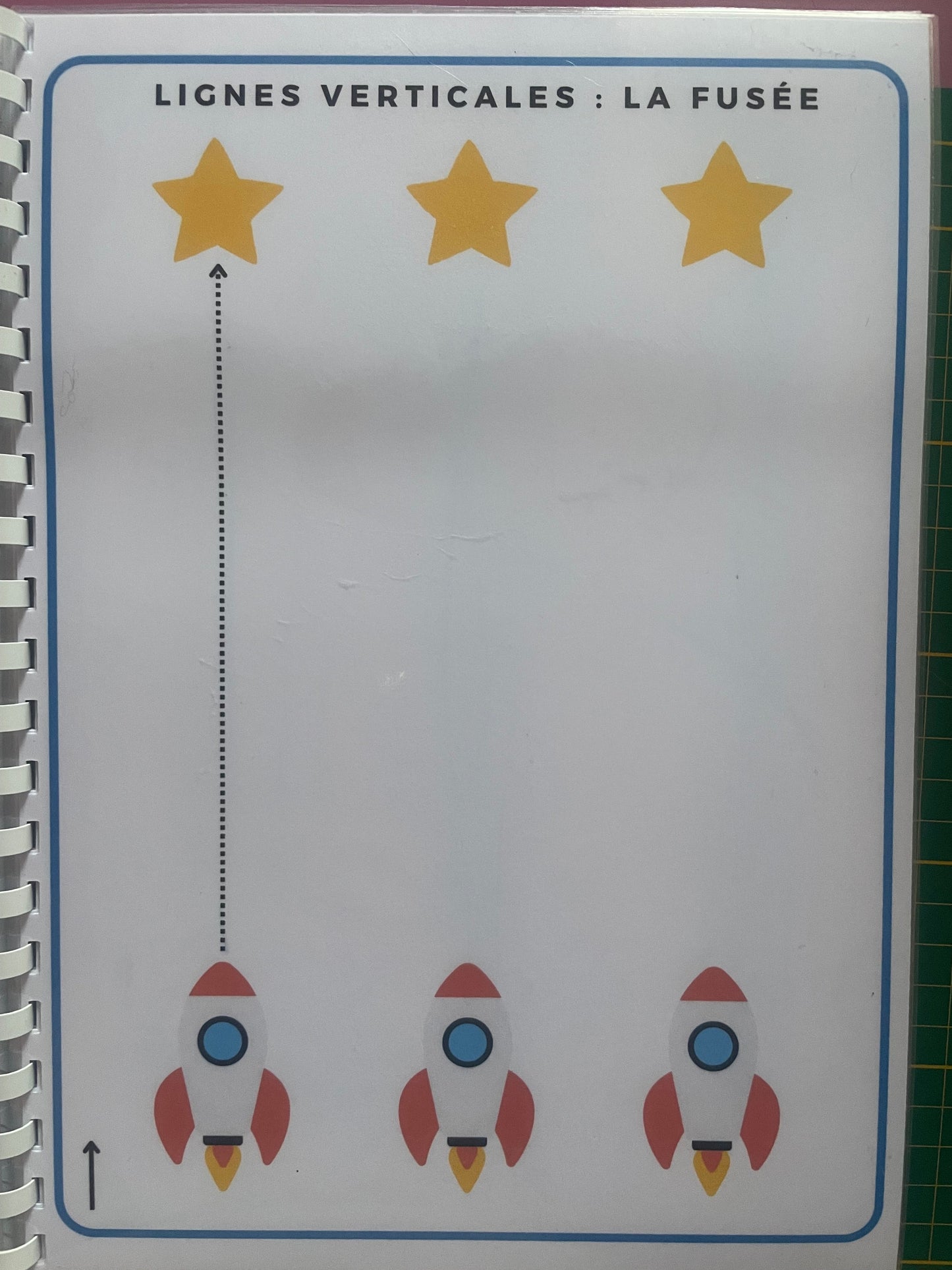Page du livret de graphisme avec exercice de lignes verticales - la fusée pour enfants en maternelle.