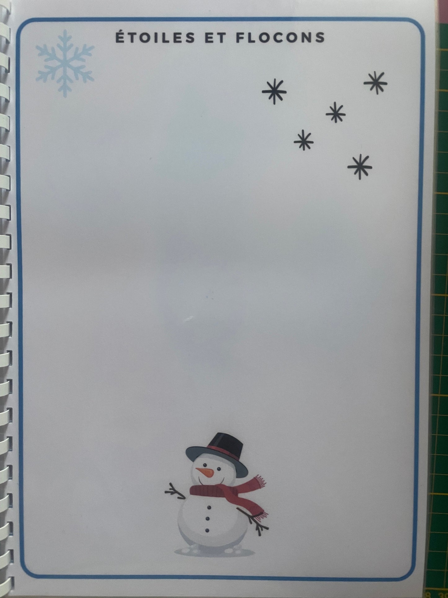 Page du livret de graphisme avec motifs étoiles, flocons et bonhomme de neige pour motricité fine enfant.